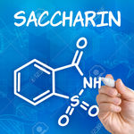 23076634-Hand-with-pen-drawing-the-chemical-formula-of-saccharin-Stock-Photo.jpg